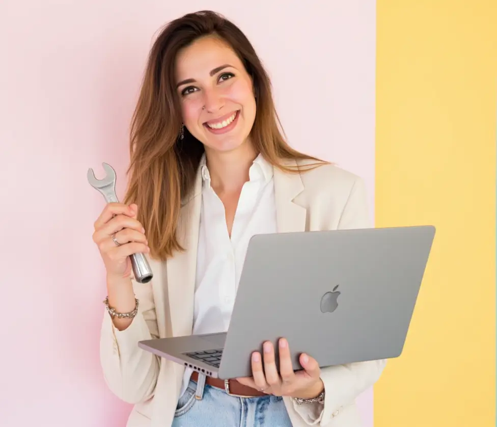 Mantenimiento web WordPress. Mujer con americana, portátil y llave inglesa sobre fondo rosa y amarillo
